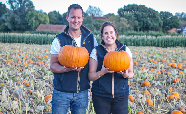 Owners, Emily and Guy Holding a pumpkin