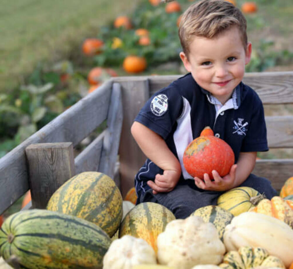 Kid posing with vegetables